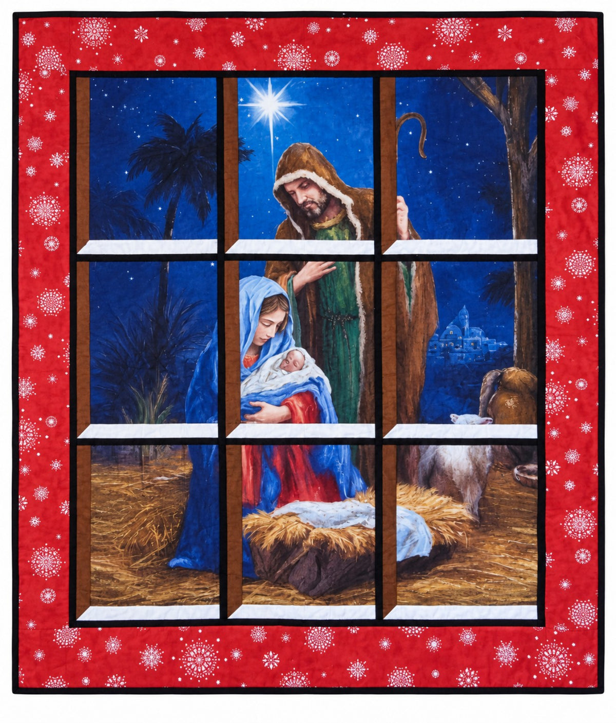 Quilted window-style wall hanging depicting nativity scene showing Mary cradling baby Jesus beside the manger with Joseph and lamb gazing down on Jesus, beneath the Star of Bethlehem, framed by a red border with white snowflakes.