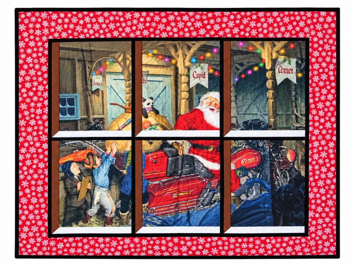 Quilted window-style wall hanging depicting Santa on a motorcycle named Comet with elves packing it with toys beneath colorful Christmas lights, framed by a red border with white snowflakes.